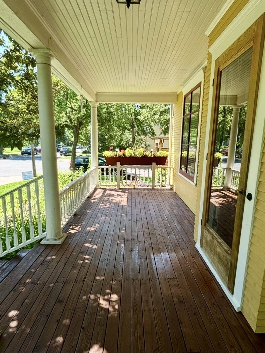 The same front porch after stripping, sanding and staining — an even, deep reddish-brown across every board