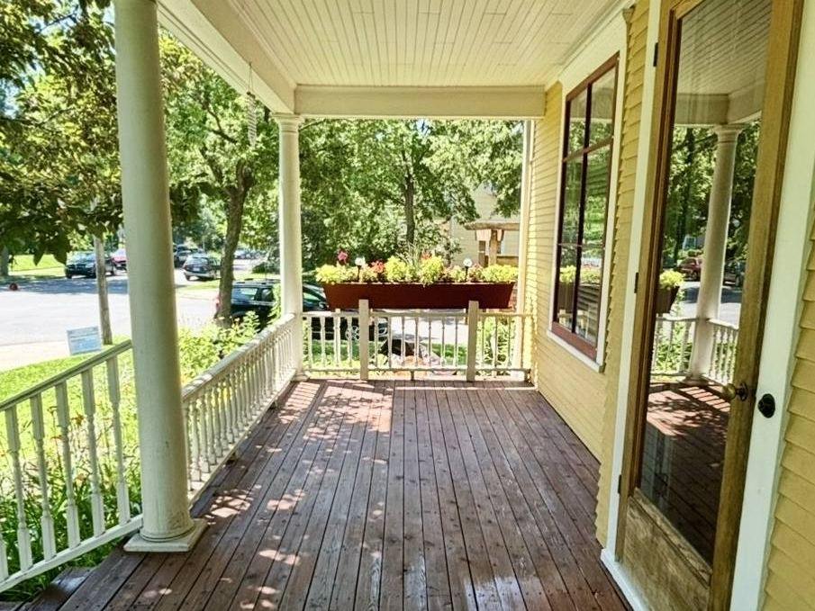 A Victorian front porch floor finished in a deep reddish-brown stain